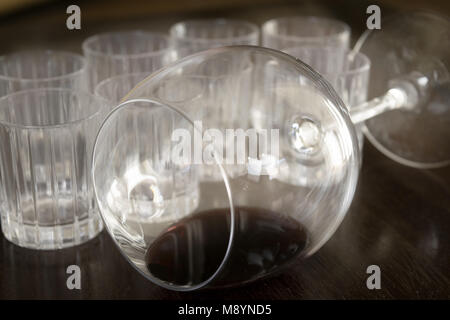 Cristallo ribaltata wineglass con resti di vino all'interno vicino al liquore bicchieri Foto Stock