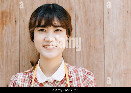 Ragazza asiatica young teen hipster closeup testa sorriso felice annata su uno sfondo di legno Foto Stock