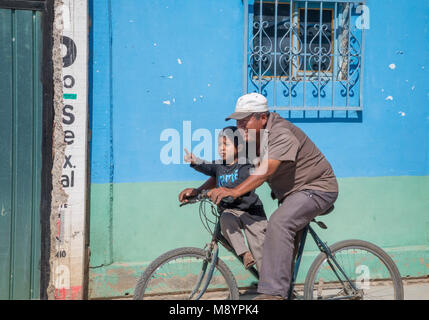 San Juan Teitipac, Oaxaca, Messico - un uomo e un ragazzo su una bicicletta in una piccola città zapoteco. Foto Stock