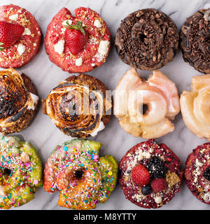 Varietà di ciambelle su un piano di marmo Foto Stock