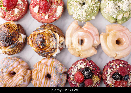 Varietà di ciambelle su un piano di marmo Foto Stock
