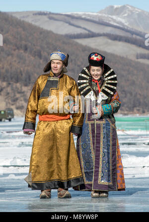 Hatgal, Mongolia, 4 Marzo 2018: popolo mongolo vestito in abiti tradizionali su un lago ghiacciato Khuvsgul Foto Stock