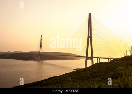 Cavo-alloggiato ponte Russky 'Ponte' in isola Russkiy sul tramonto. Vladivostok, Primorsky Krai, Russia Foto Stock