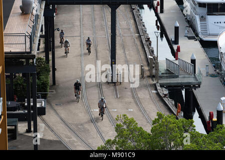 Gli uomini più anziani di andare in bicicletta su un convertito freight wharf in Prymont, Sydney. Questo storico pontile del dito è ora convertito per alloggiamento e uso pubblico Foto Stock