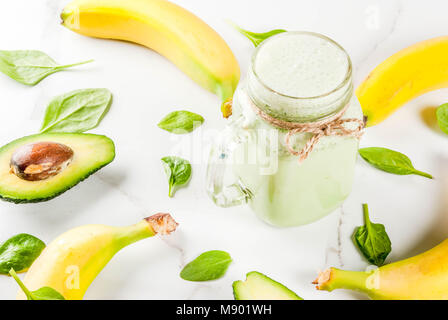 Frullato sano con banana e baby spinaci, n marmo bianco di sfondo spazio di copia Foto Stock