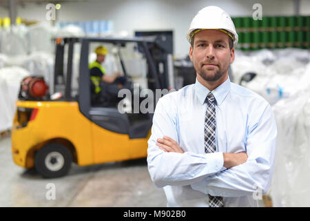 Gruppo di lavoratori nell'industria logistica lavorare in un magazzino con sostanze chimiche Foto Stock