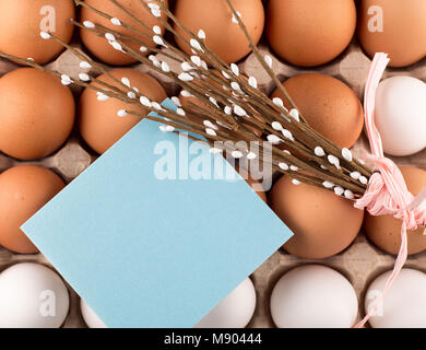 Uova di Pasqua nel nido dalla parte superiore vista guardando verso il basso di colore bianco o grigio in legno rustico sfondo con camera o spazio per copiare testo, parole buona Pasqua Foto Stock