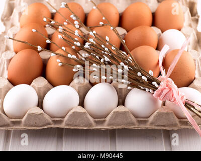 Uova di Pasqua nel nido dalla parte superiore vista guardando verso il basso di colore bianco o grigio in legno rustico sfondo con camera o spazio per copiare testo, parole buona Pasqua Foto Stock