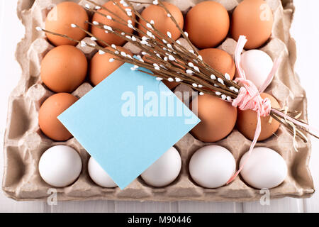 Uova di Pasqua nel nido dalla parte superiore vista guardando verso il basso di colore bianco o grigio in legno rustico sfondo con camera o spazio per copiare testo, parole buona Pasqua Foto Stock