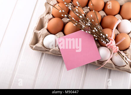 Uova di Pasqua nel nido dalla parte superiore vista guardando verso il basso di colore bianco o grigio in legno rustico sfondo con camera o spazio per copiare testo, parole buona Pasqua Foto Stock