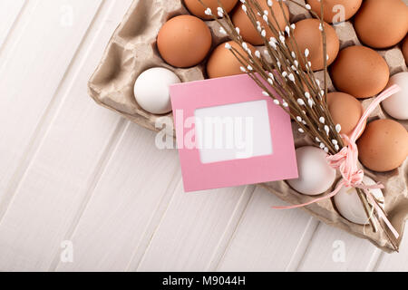 Uova di Pasqua nel nido dalla parte superiore vista guardando verso il basso di colore bianco o grigio in legno rustico sfondo con camera o spazio per copiare testo, parole buona Pasqua Foto Stock