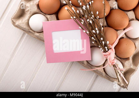 Uova di Pasqua nel nido dalla parte superiore vista guardando verso il basso di colore bianco o grigio in legno rustico sfondo con camera o spazio per copiare testo, parole buona Pasqua Foto Stock