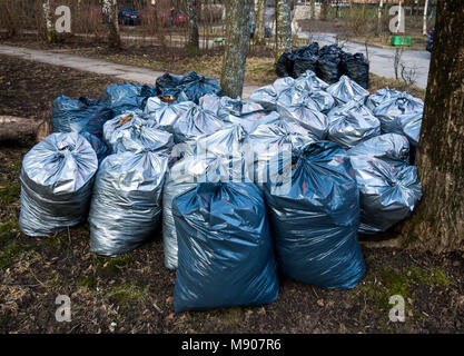 Sacchetti di plastica con cestino dopo la raccolta nel parco Foto Stock