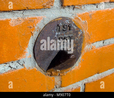 Geodetic (segno) sul muro di mattoni della casa Foto Stock