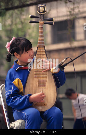 Pechino, Cina, middle school femmina, bambino , RPC, giocando Pípa Cinese (琵琶) liuto, strumenti a pizzico quattro corde cinese.lo strumento musicale Foto Stock