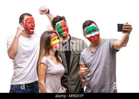 Gruppo di persone appassionati tifosi delle squadre nazionali dipinta la faccia di bandiera del Portogallo, Spagna, Marocco, Iran prendere selfie dal telefono. Foto Stock