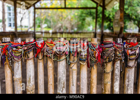 Braccialetti colorati lasciati dai visitatori presso il sito di una massa grave, Choeung Ek Killing Fields genocidio centro, Phnom Penh, Cambogia, sito in cui decine di migliaia di persone in Cambogia sono stati uccisi dalla Khymer Rouge sotto gli ordini di Pol Pot da 1975-1979. Foto Stock