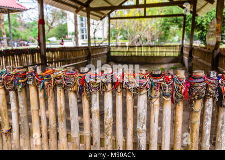 Braccialetti colorati lasciati dai visitatori presso il sito di una massa grave, Choeung Ek Killing Fields genocidio centro, Phnom Penh, Cambogia, sito in cui decine di migliaia di persone in Cambogia sono stati uccisi dalla Khymer Rouge sotto gli ordini di Pol Pot da 1975-1979. Foto Stock