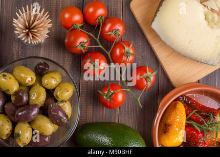 Miscelati tapas spagnole partenti sulla tabella. Formaggio Manchego, olive e peperoni grigliati. Vista superiore Foto Stock