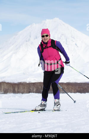 Penisola di Kamchatka: sportive sciatore che corre lungo inverno sci via sullo sfondo del vulcano. Massa All-Russia gara di sci - pista di sci della Russia Foto Stock