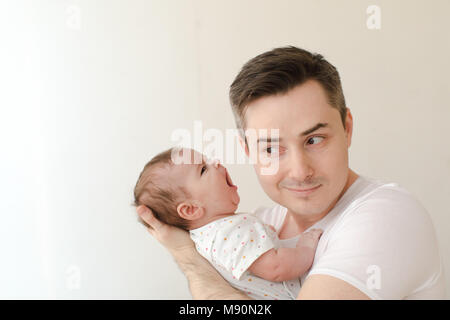 Uomo sorridente con screaming baby Foto Stock