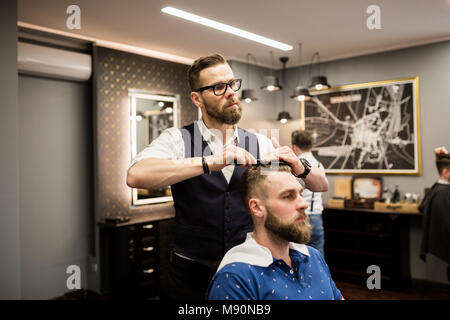 Ritratto di parrucchiere pettinatura dei capelli del cliente Foto Stock