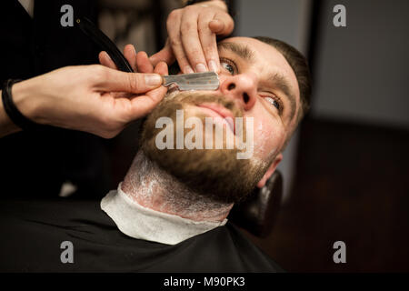 Ritratto di giovane uomo avente rasoio barba rasata Foto Stock