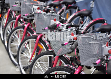 Fila di nuove biciclette con carrelli per gli acquisti nel negozio di sport Foto Stock