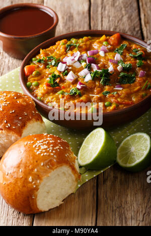 Indian Mumbai cibo Pav bhaji dalle verdure con pane di close-up in una ciotola sul piano verticale. Foto Stock