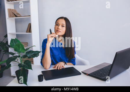 Donna foto retoucher presso la sua sede di lavoro Foto Stock