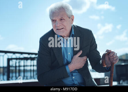 Esaurito uomo anziano sentire dolore in area del cuore Foto Stock