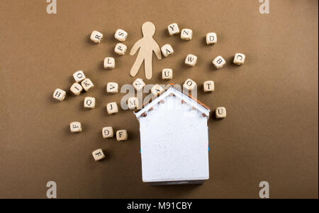 Lettera di legno cubi e figurine di uomo e modello di casa Foto Stock