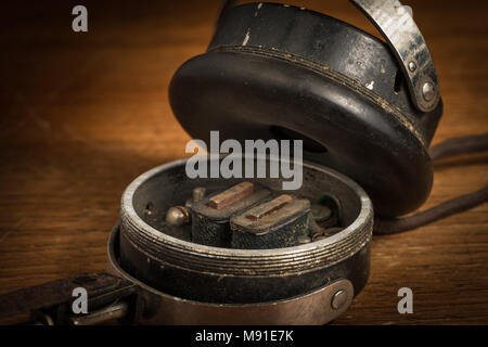Dettaglio del vecchio rotto vintage auricolari su un tavolo di legno Foto Stock