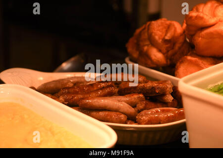 Cuocere le salsicce chipolata per un tacchino arrosto o pollo a cena Foto Stock