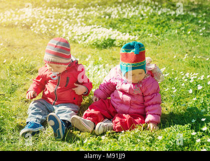 Piccolo Ragazzo e ragazza di cappelli di seduta sul campo con i peluche in estate Foto Stock