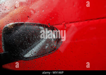 Stagione dei monsoni. close-up di gocce di pioggia sulla finestra di vetro in auto. Gocce di acqua di pioggia sul finestrino. Ho Chi Minh City. Il Vietnam. Foto Stock