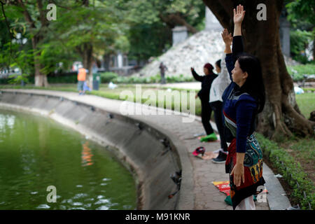 Le donne fanno tai chi al mattino sulle rive del Lago Hoan Kiem Hanoi. Il Vietnam. Foto Stock