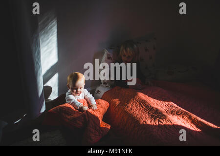 Bambino nella culla babydoll luce drammatica trendy camera per bambini Foto Stock