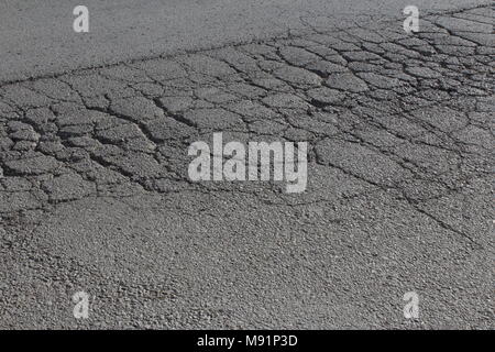 Asfalto danneggiato in strada Foto Stock