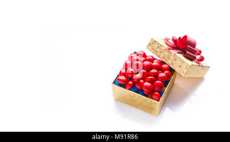Il colore è dorato confezione di cioccolato colorato su sfondo bianco con fiocco rosso, con spazio per il testo Foto Stock