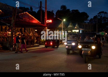 La strada principale di Ella sera notte tempo con tuk tuks, ristoranti, bar, turisti e gente del posto. Rallentare la velocità dello shutter e high iso in modo motion blur. Foto Stock