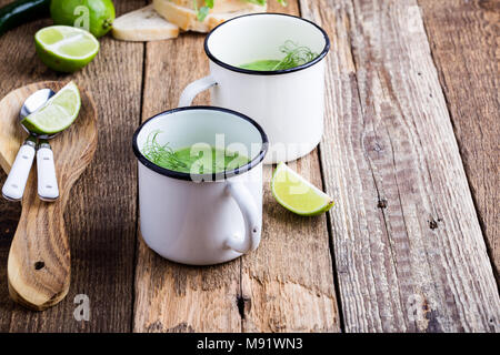 Minestra di crema con pisello verde erbe fresche e i germogli con micro verdi sulla parte superiore nelle zone rurali a tazze, sano pasto vegetariano Foto Stock