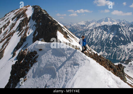 Alpinista sul crinale di Szpiglasowy Wierch (vertice) in maggio, Monti Tatra, Polonia Foto Stock