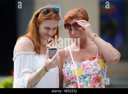 Madre e figlia guardando il suo cellulare in strada, Vilnius, Lituania Foto Stock