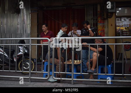2 street giocatori di scacchi seduto da strada su sedie di plastica al centro di Bangkok circondato dagli spettatori. Foto Stock