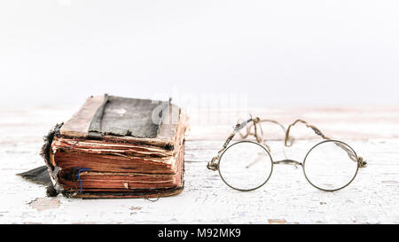 Antico libro di preghiera con i vecchi occhiali sul tavolo di legno, vista in un angolo, banner con spazio di copia Foto Stock