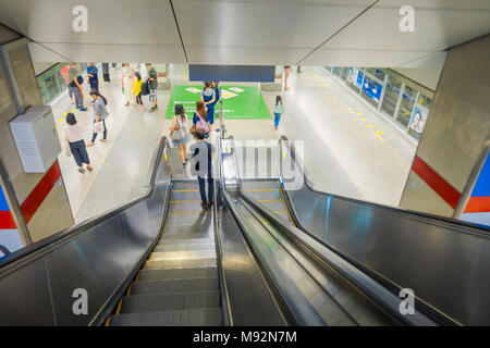 BANGKOK, Thailandia, febbraio 08, 2018: persone non identificate utilizzando scale elettrico per attendere MRT della metropolitana e del treno utilizzando gli smartphone a uccidere il tempo in ore di punta, trasporto di Bangkok Mass Rapid Transit Foto Stock