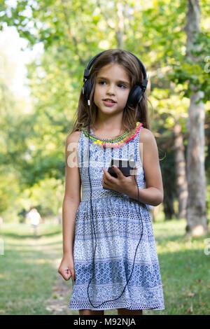 Carino bambina ascoltando musica Foto Stock