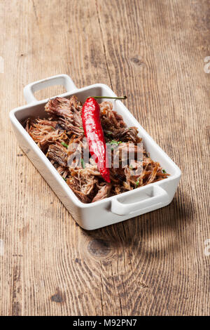 Tirate la carne di maiale in una ciotola Foto Stock