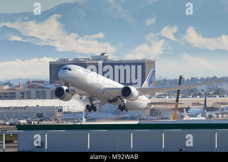 United Airlines Boeing Dreamliner 787-900 jet del passeggero il decollo dall'Aeroporto di Los Angeles LAX. La coperta di neve Montagne di San Gabriel dietro. Foto Stock